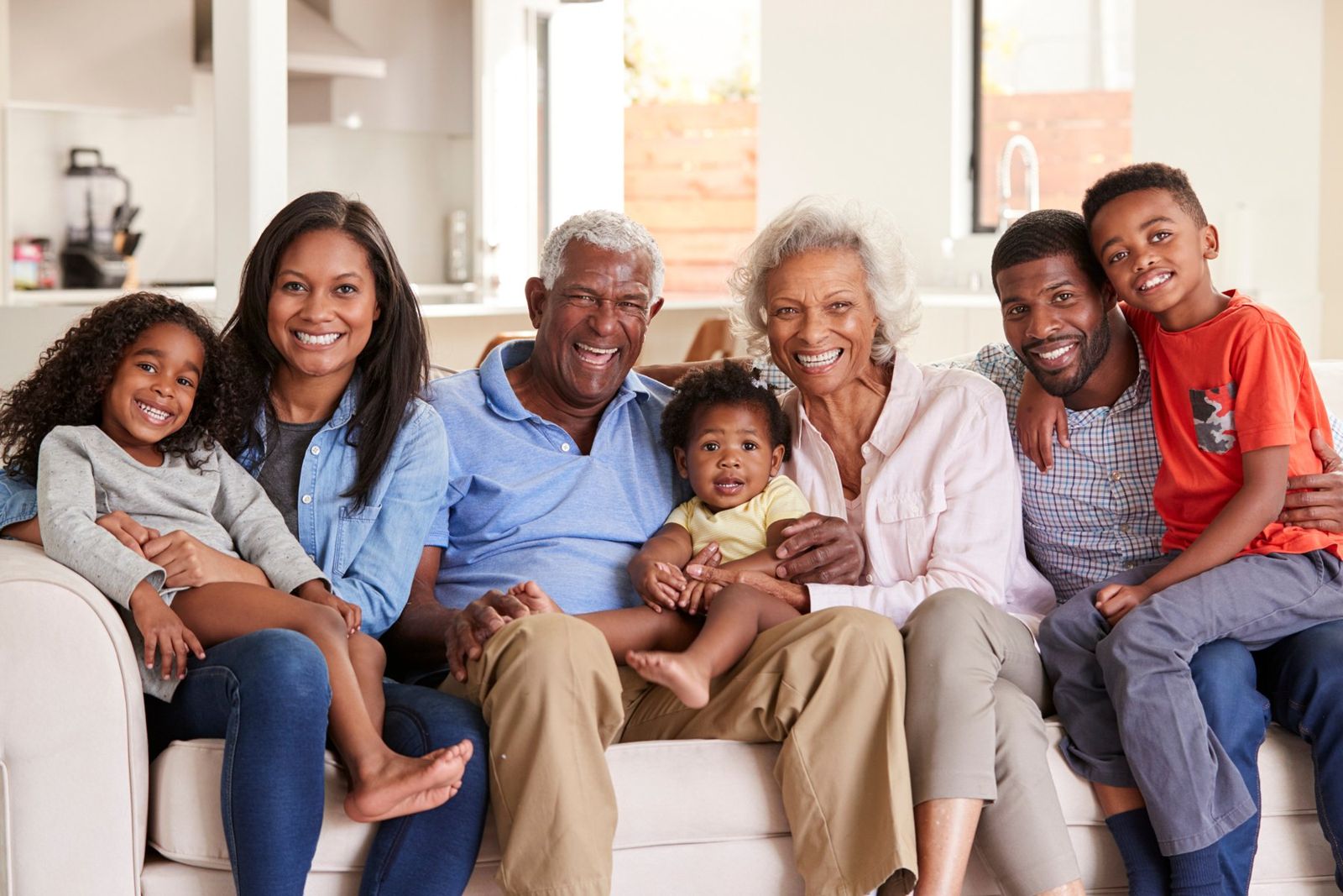 A smiling multi-generational African family sitting together on a sofa